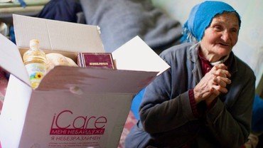 Ældre kvinde modtager nødhjælps pakke.